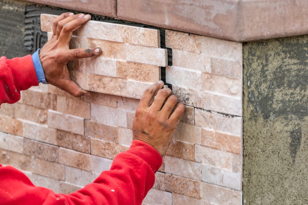 Worker Installing Wall Tile at Construction Site